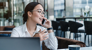 woman making a call in front of a laptop