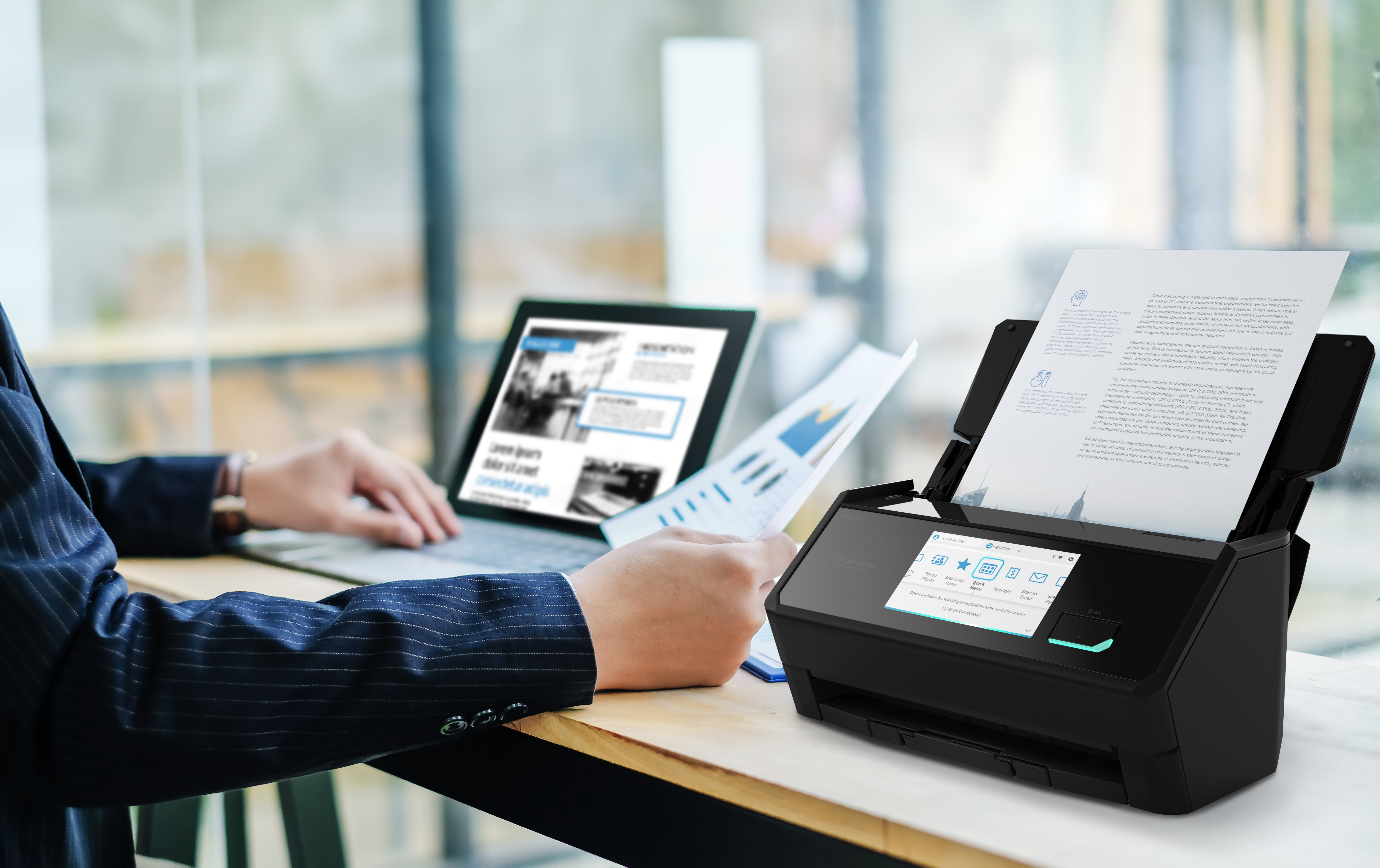 a person's using the iX2500 to scan documents next to a laptop